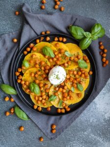 Scheiben vom Butternusskürbis mit gerösteten Kichererbsen und Burrata