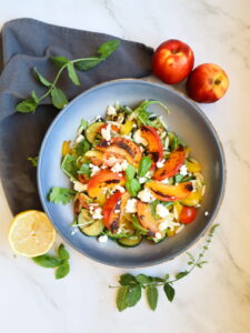 Eine Schüssel Orzo-Nudelsalat mit Zucchini und gegrillten Nektarinen